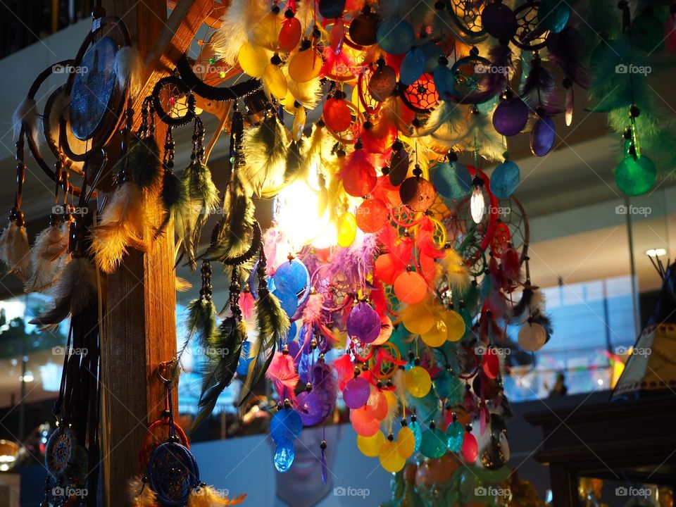 Colorful feathery souvenirs hanging in a store.