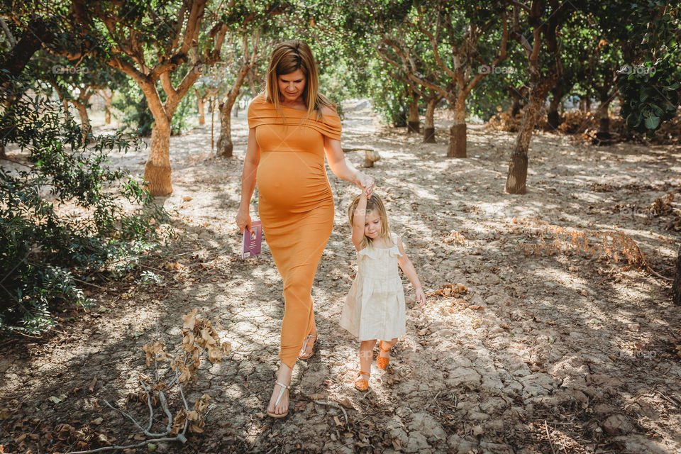 Pregnant mom walking with daughter 
