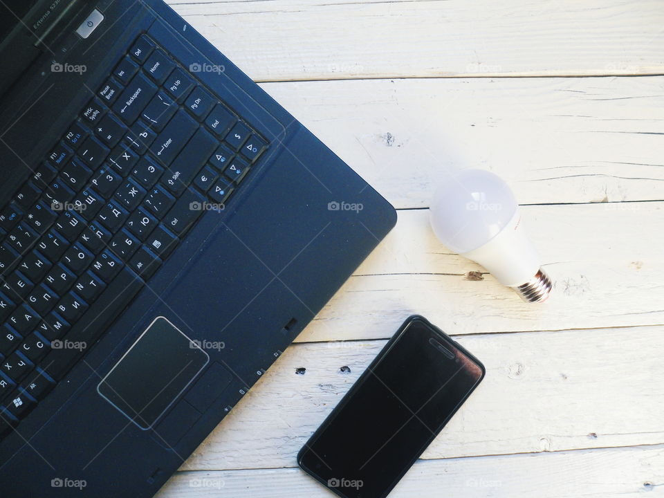 laptop, energy-saving light bulb and smartphone