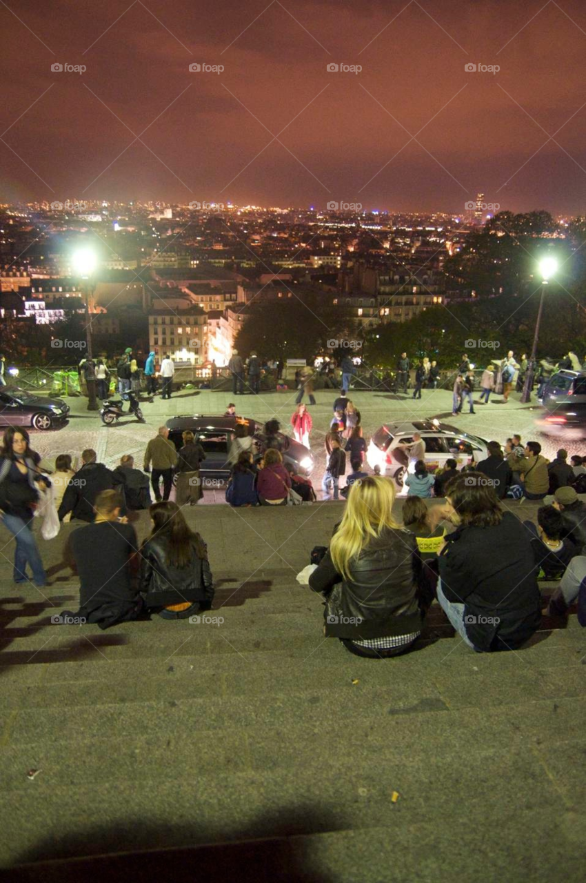 People hang out in Paris . People hang out on a street in Paris at night 