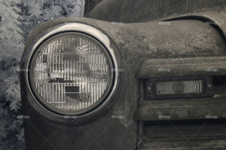 One headlight from an old rusty chevy pickup
