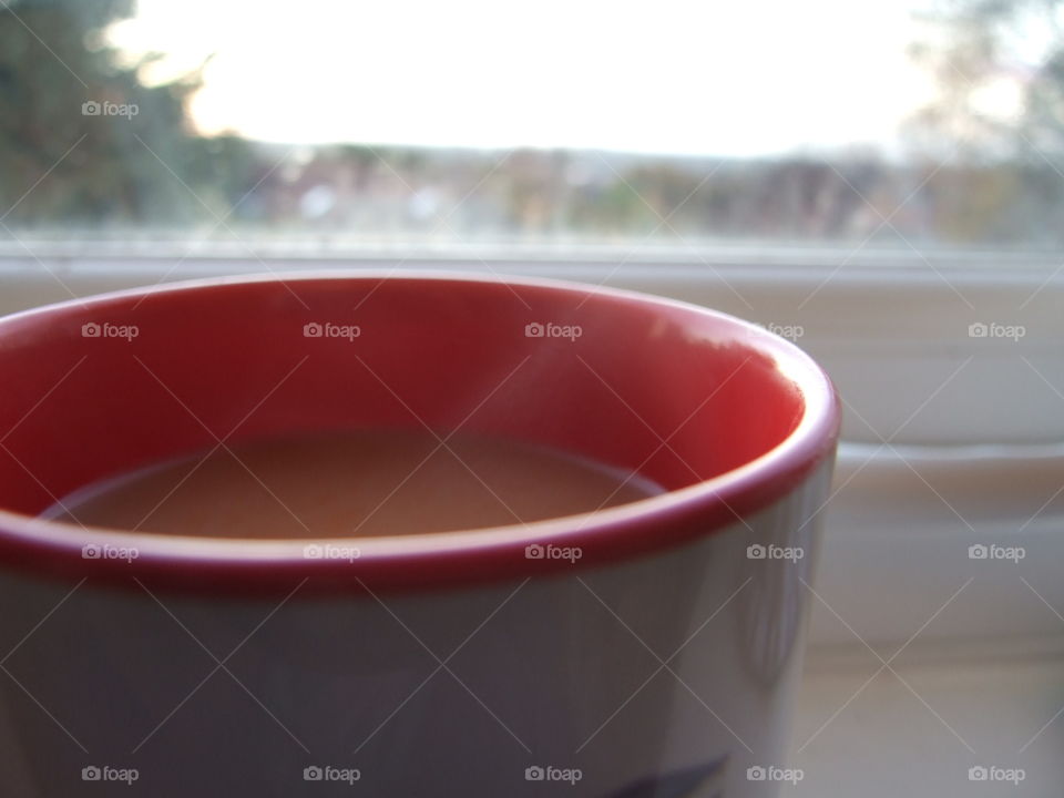 Steam rising from tea in a red and white mug