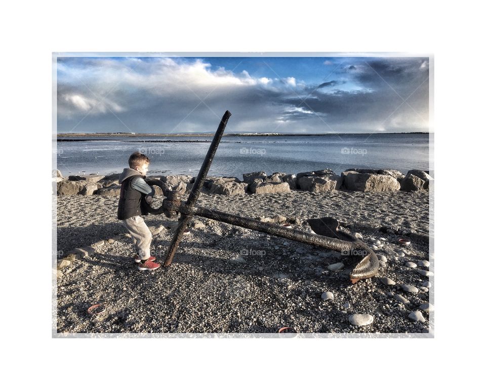 Boy standing near the anchor