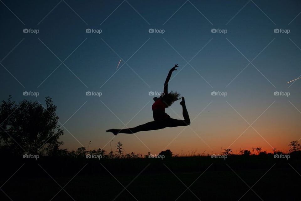 Silhouette of a woman dancing during sunset