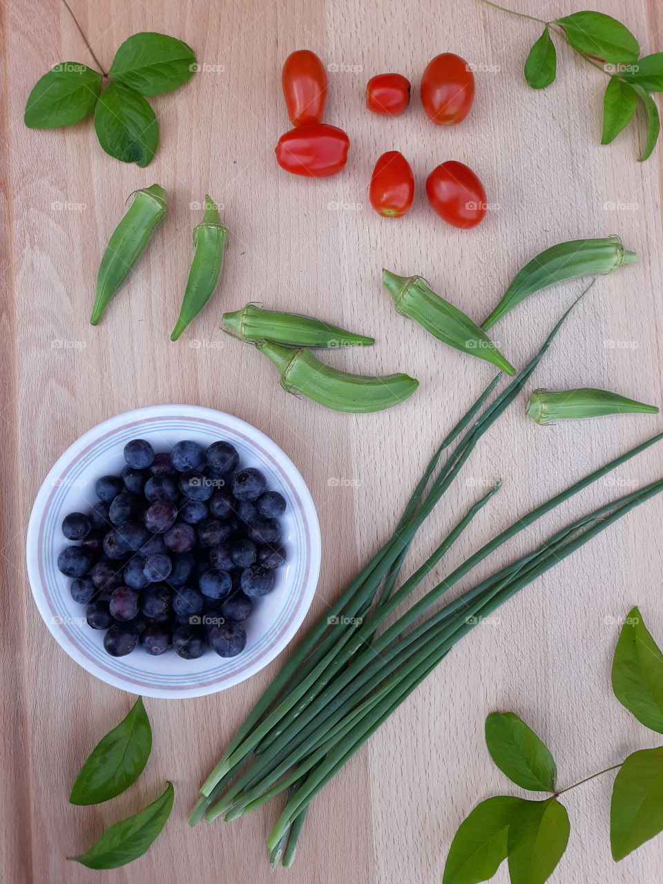 Garden haul with blueberries, onions, okra, and cherry tomatoes
