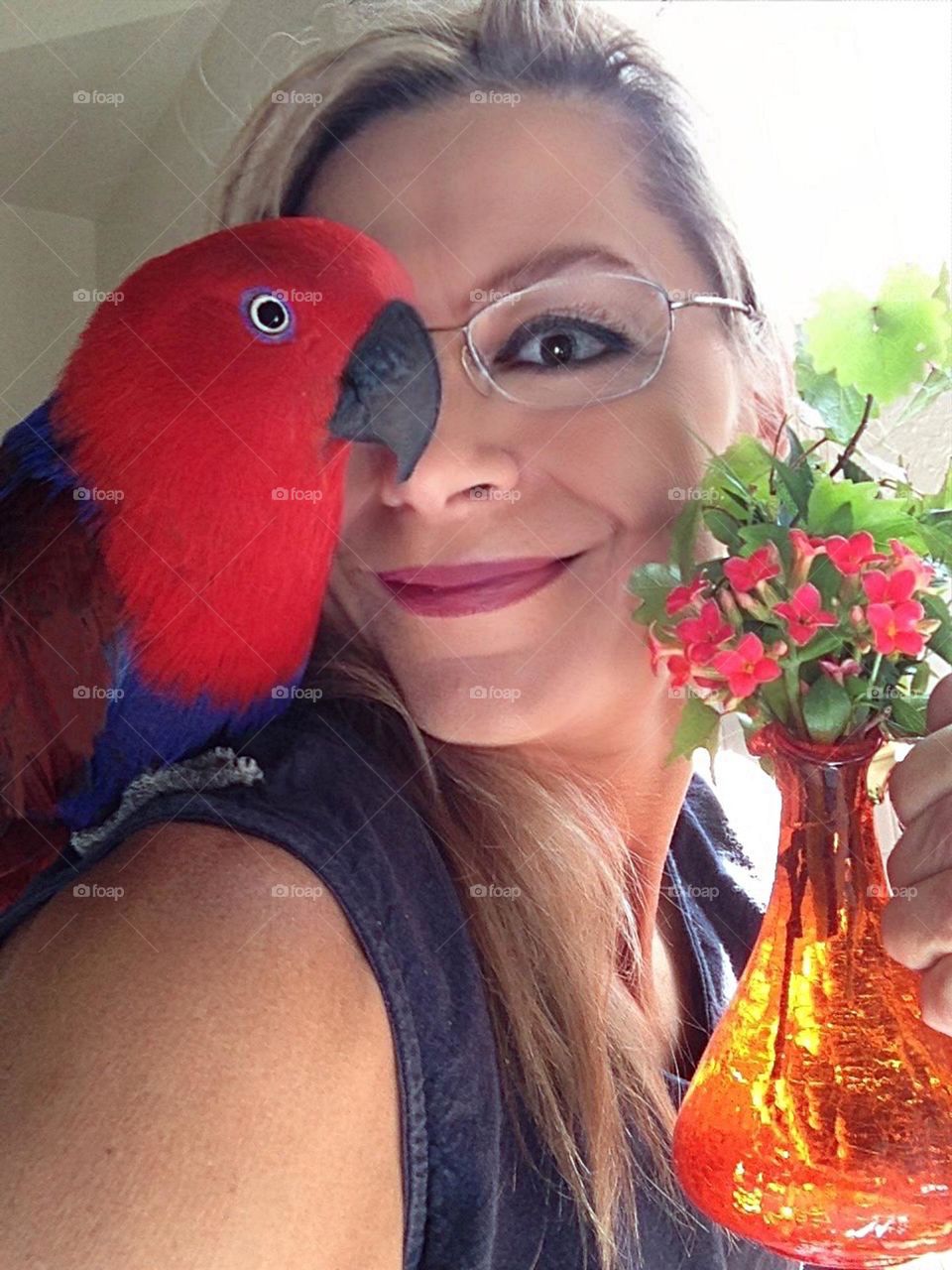 Summer-snapshot of a woman and her red Parrot.