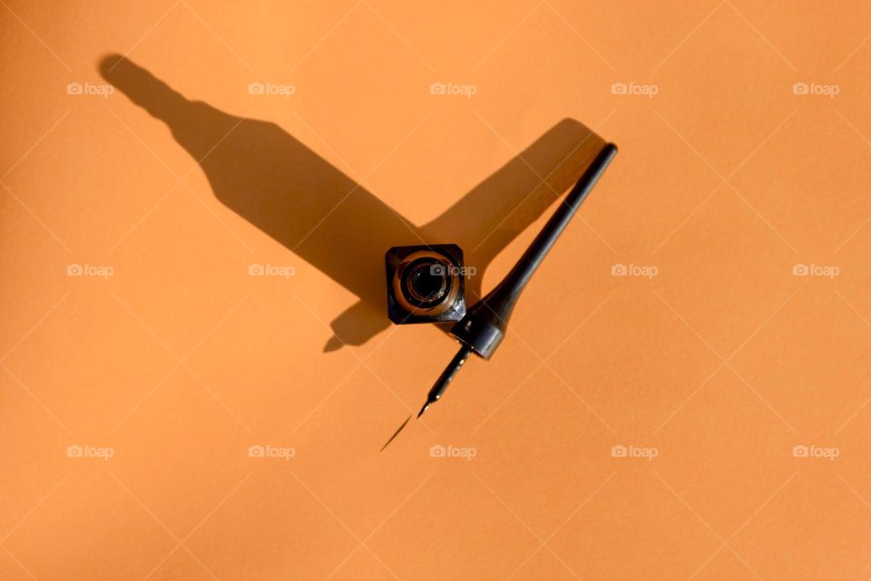 Black eyeliner on an orange background.
