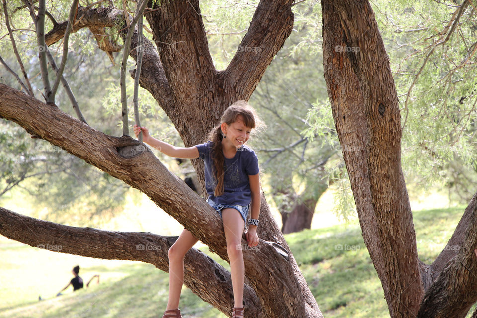 Child sitting on a branch, city park El Paso