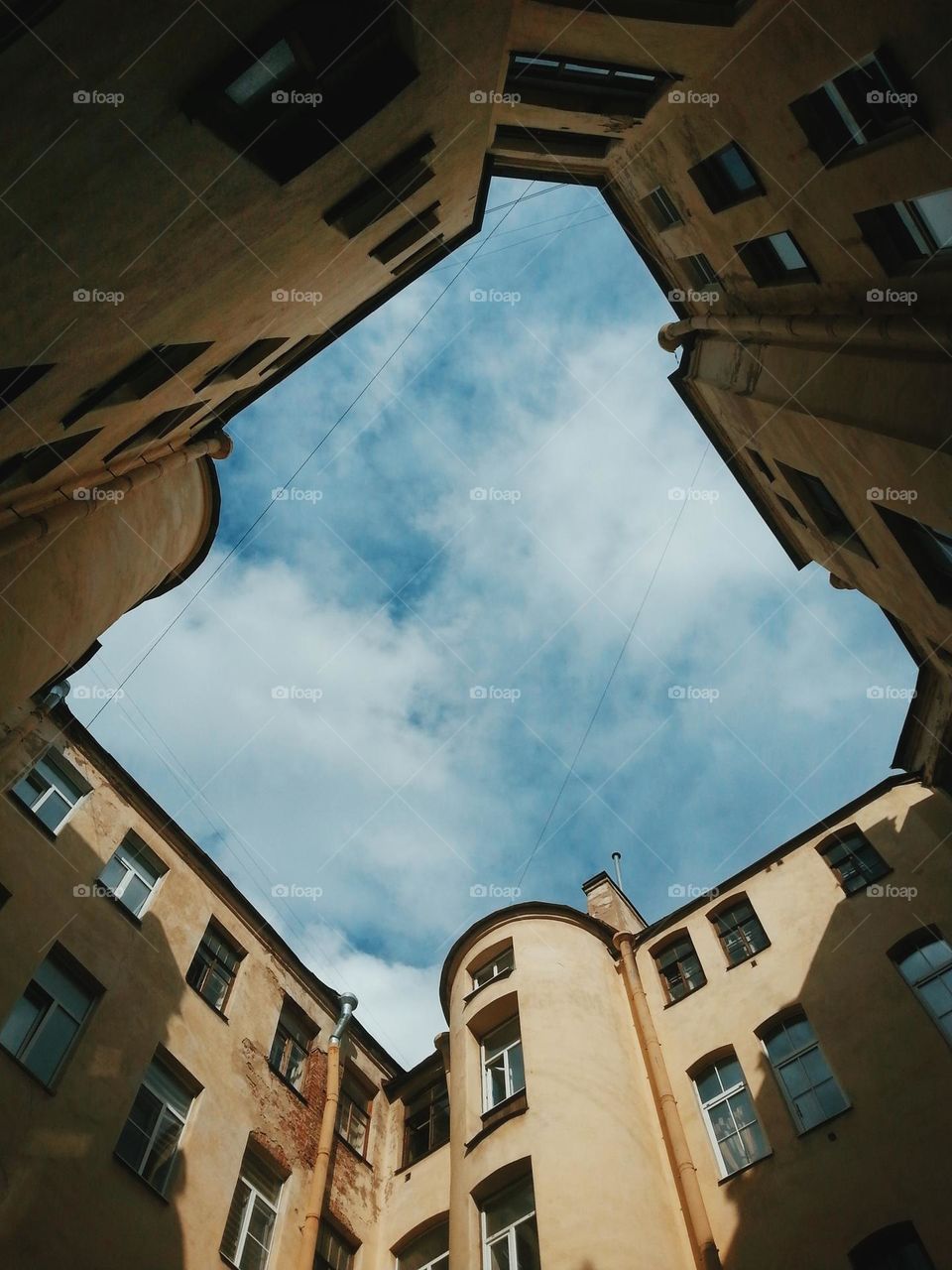 a view on the blue sky and clouds in a yard of block of flats