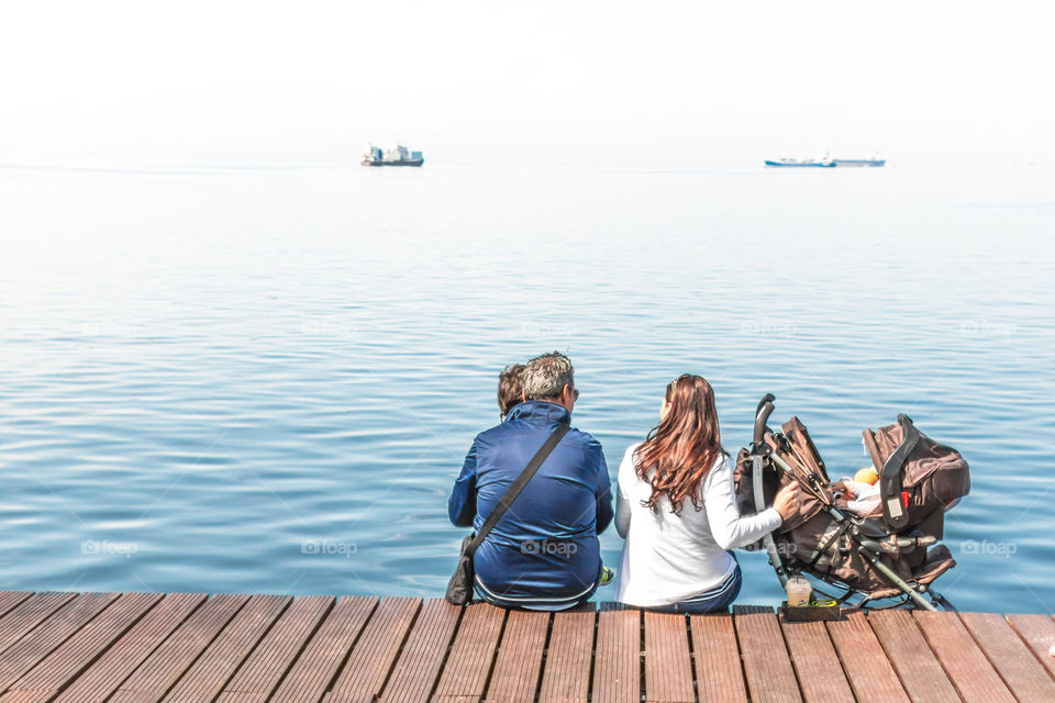 Family Enjoying The View Sitting On The Dock
