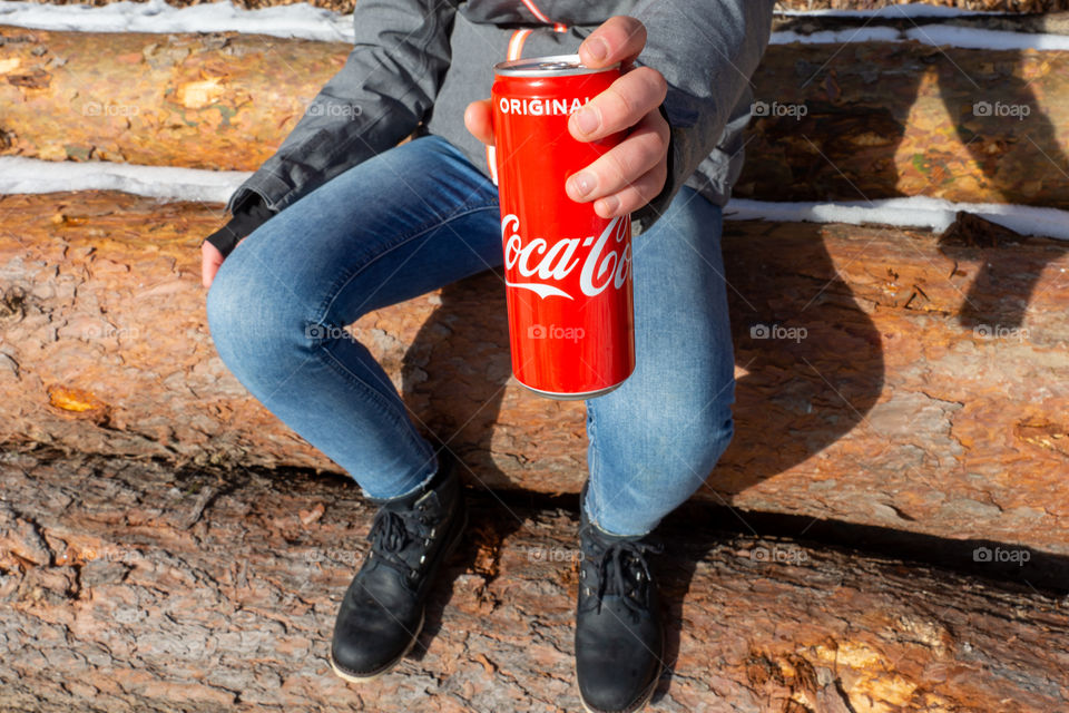 girl shows a Coca Cola tin