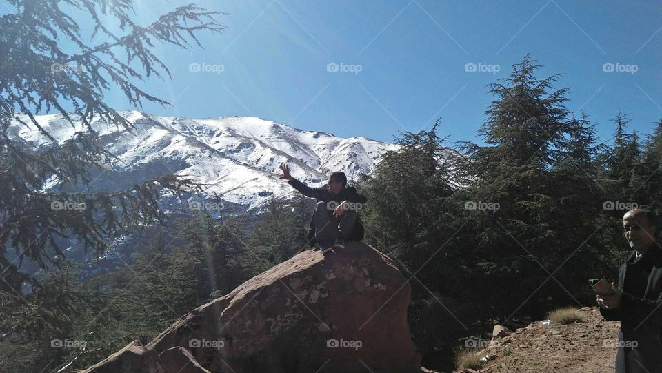 Im sitting alone on a big rock  in nature.