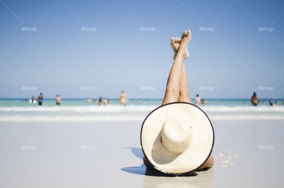 woman lying down on beach sand