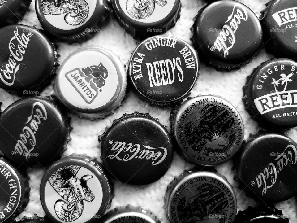 Bottle caps with various brands in black and white.