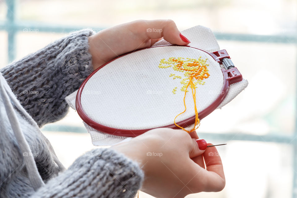 Close-up of woman doing cross-stitching