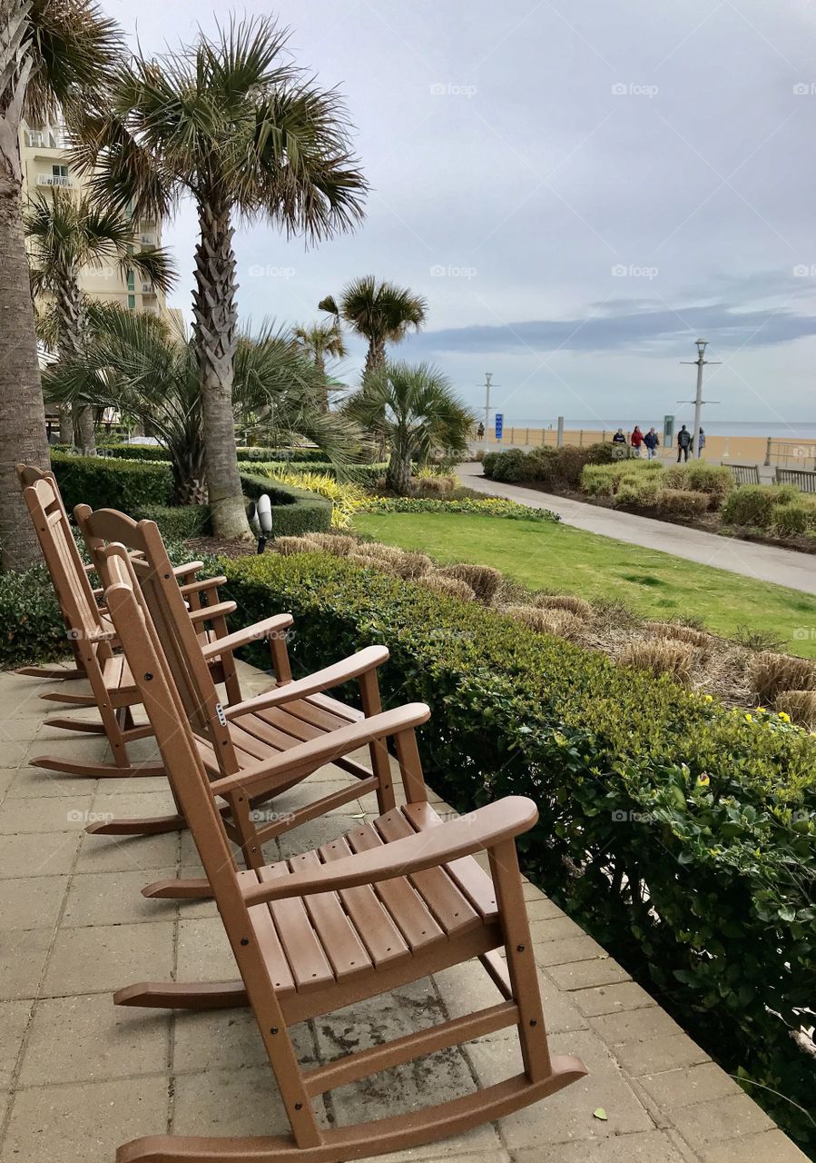 Rocking chairs sitting to ocean view