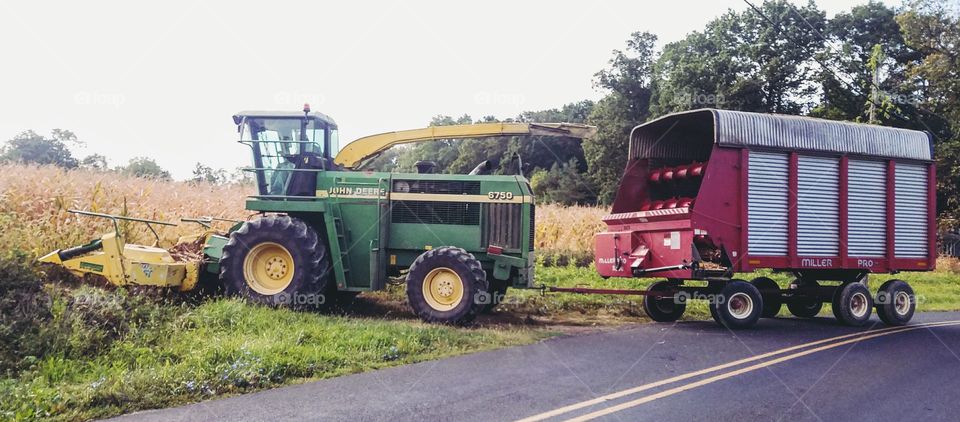 John Deere Tractor Harvesting Silage into Covered Farm Trailer