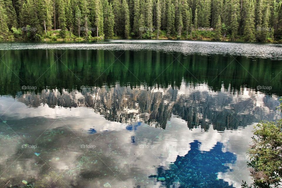 Latemar mountain range reflected on lake Carezza