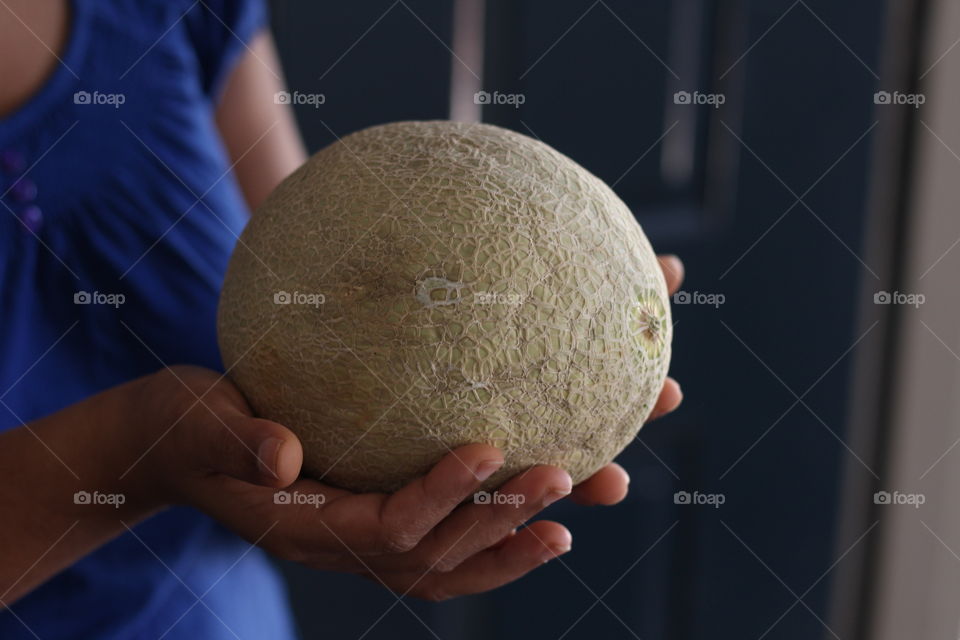 Woman holding cantaloupe fruit  