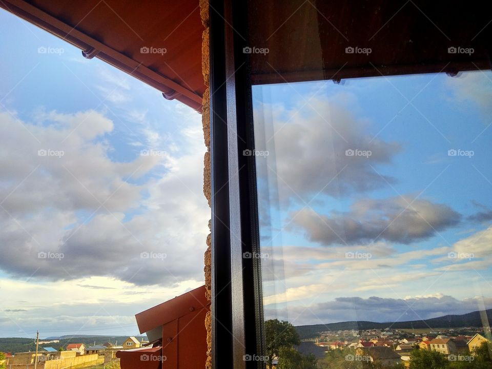 window view by foaр missions,view from the window to distant mountains, forests, houses, clouds.