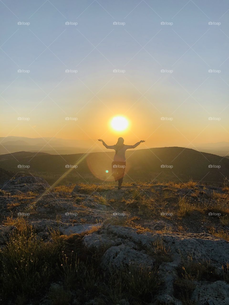 a girl meditating under the sunset in Mountain