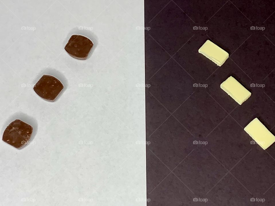 Living in harmony - Dark chocolate on white background and white chocolates black background. It’s all chocolate no matter how you look at it