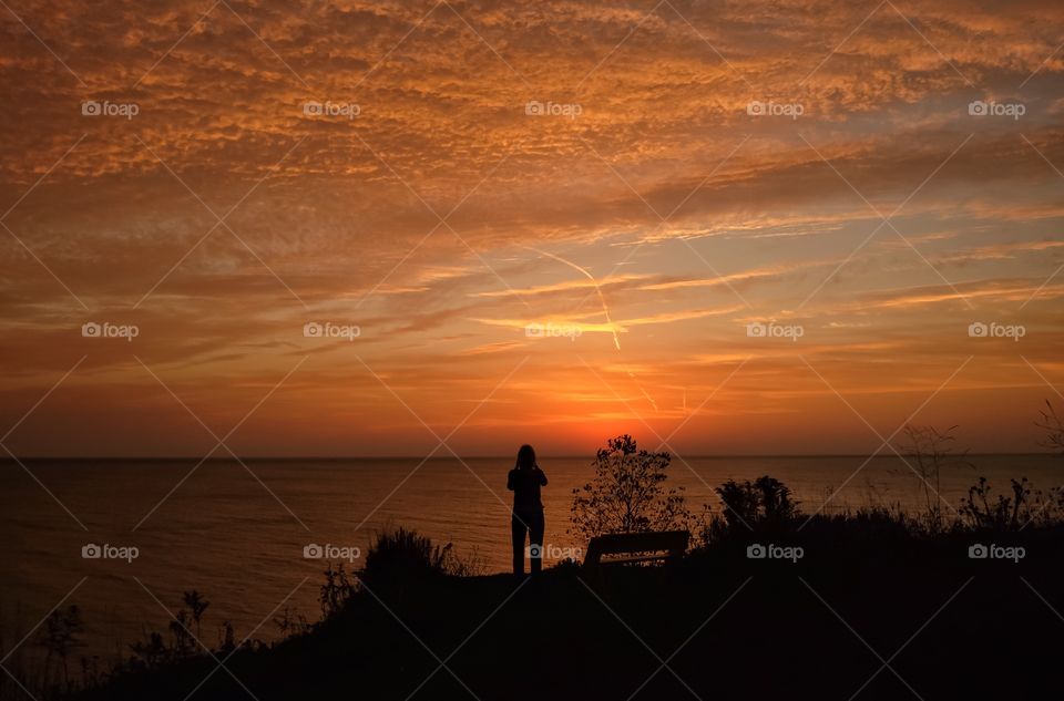 Silhouette of women standing in front of sea