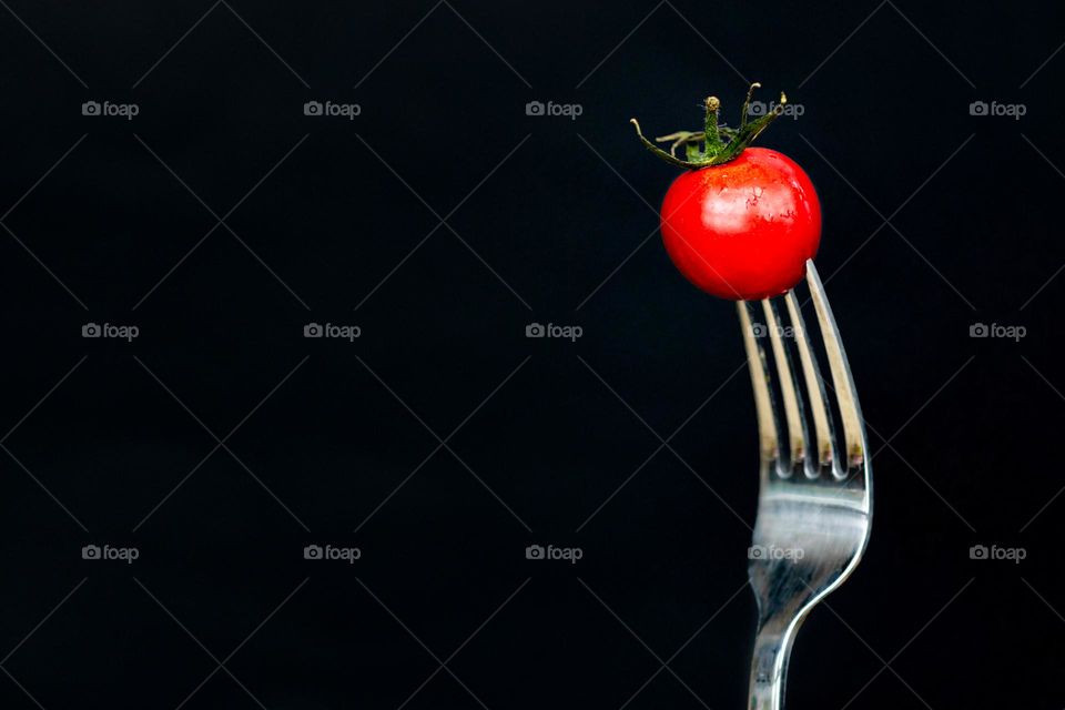 Minimal macro photography of cherry tomato on fork