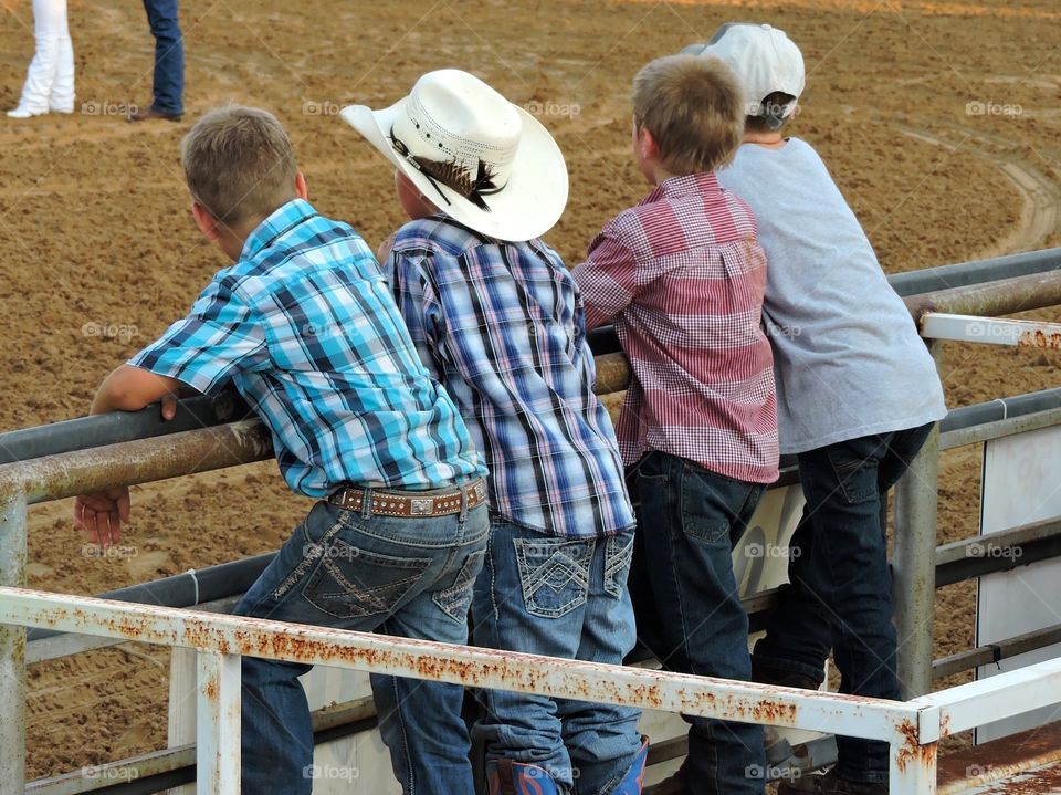 Cowboys at a fence at a country rodeo