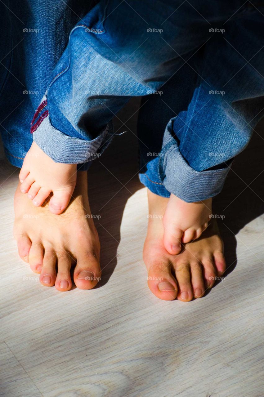 small boy foots standing on father foots