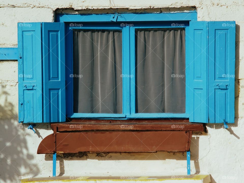 A double blue framed window in Greece