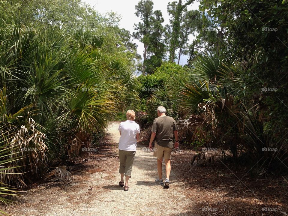 Man and woman walking through the lush tropical countryside.