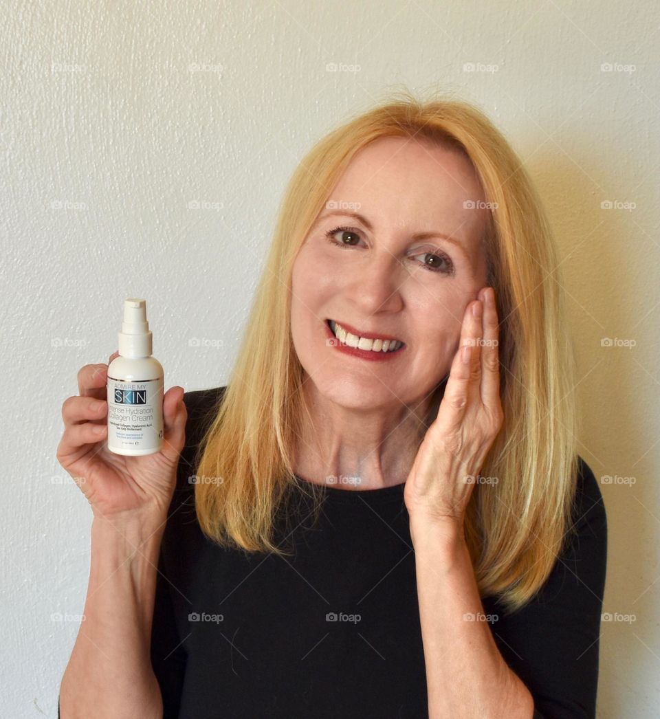 Woman putting beauty product on face