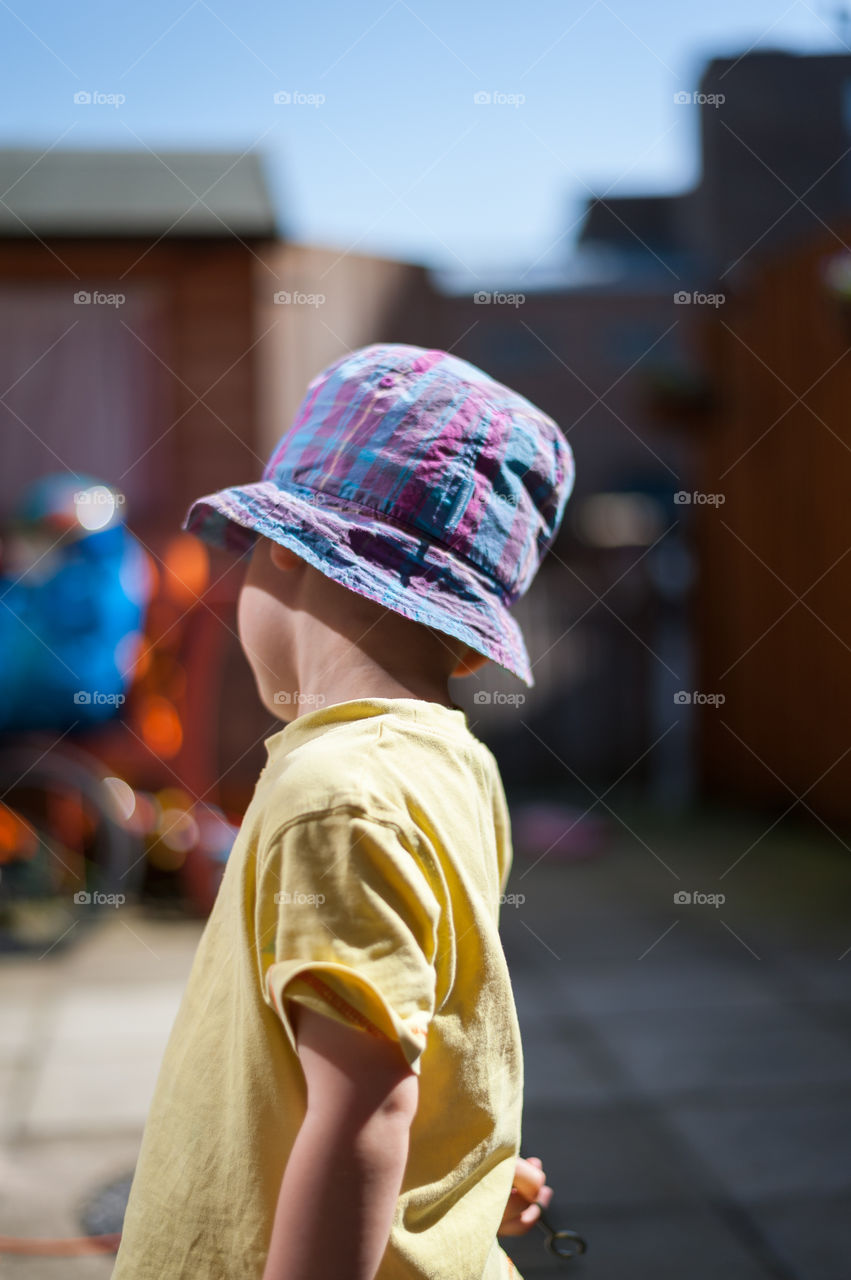 Little boy playing in garden turned around from camera.