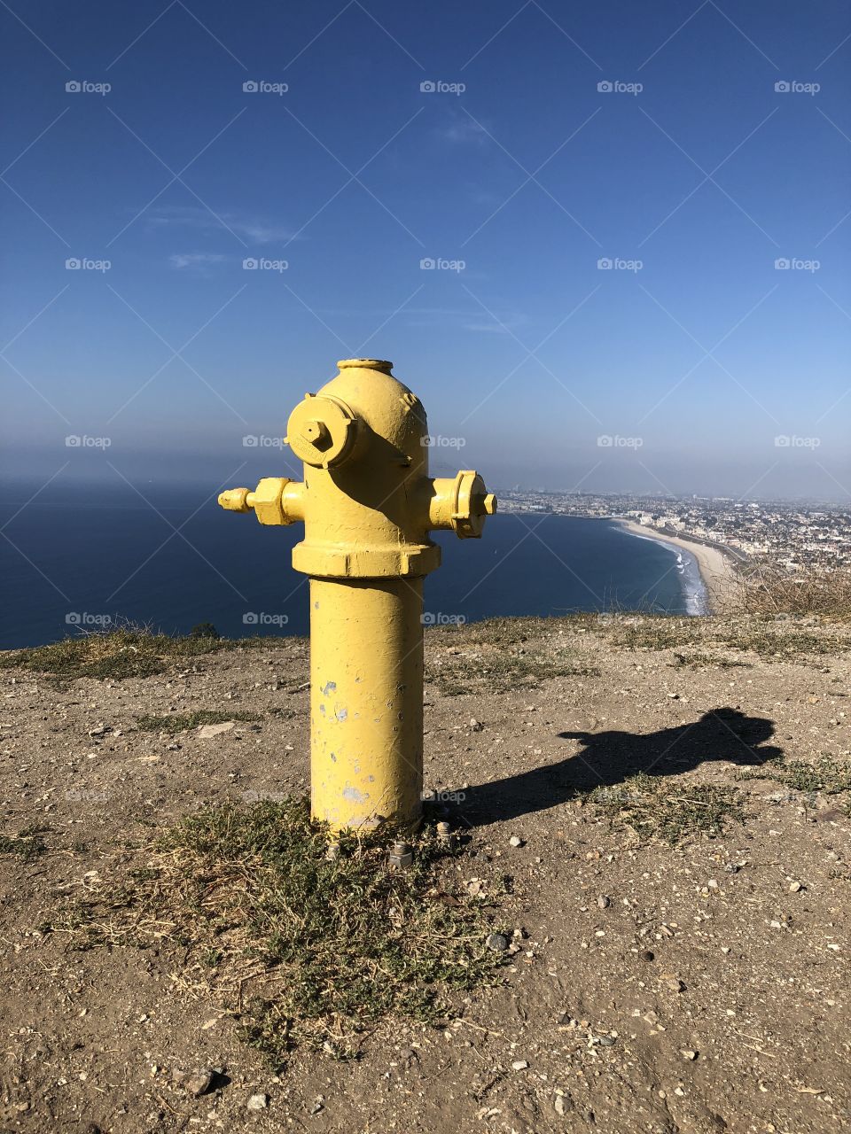 Yellow fire hydrant overlooking beach city 