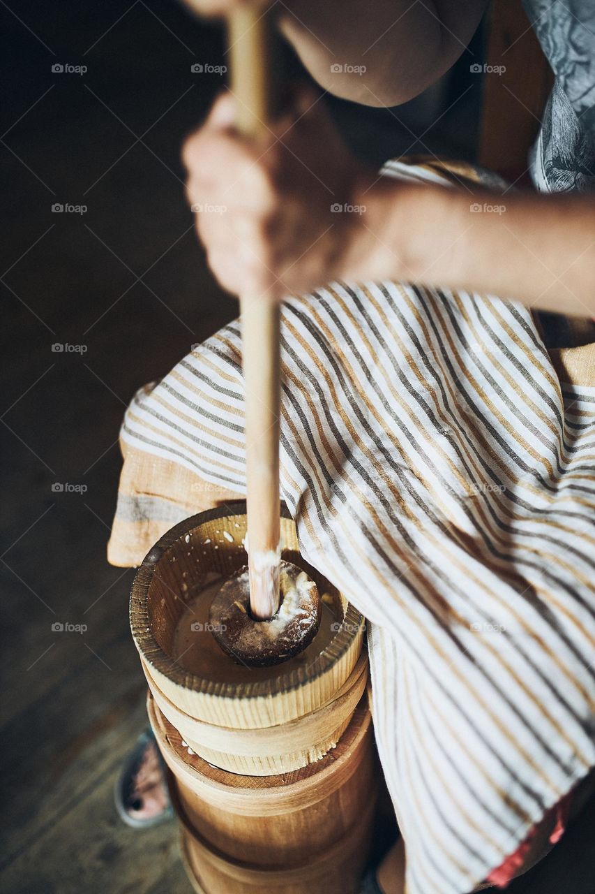 Woman making butter with butter churn. Old traditional method making of butter