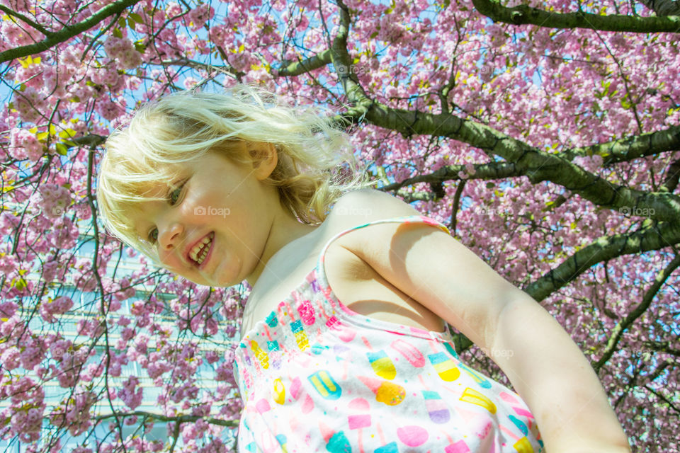 Girl standing under the cherry blossom tree