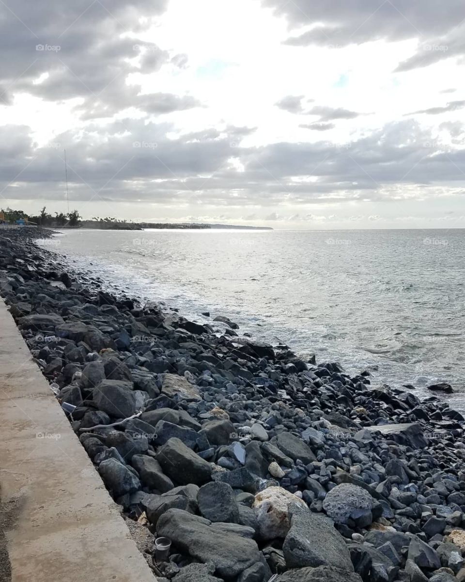 Rocky jetty boardwalk showing coastal Caribbean town in Puerto Rico