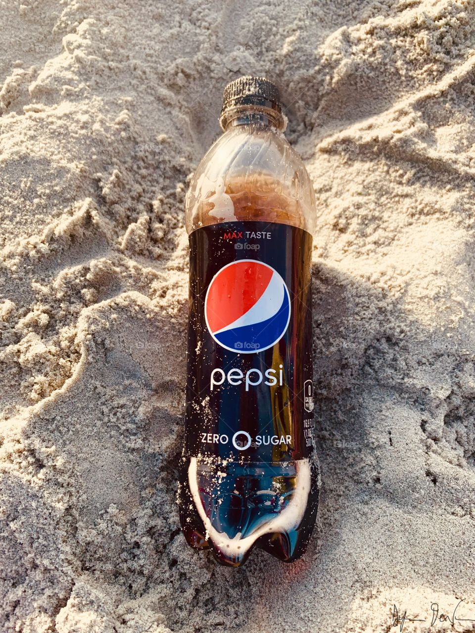 Pepsi Bottle laying in the sand 