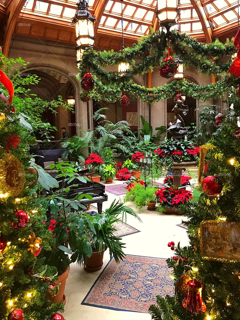 Arboretum decorated with festive wreaths, greenery, poinsettias, and Christmas trees, grand piano, architecture, Sunroof