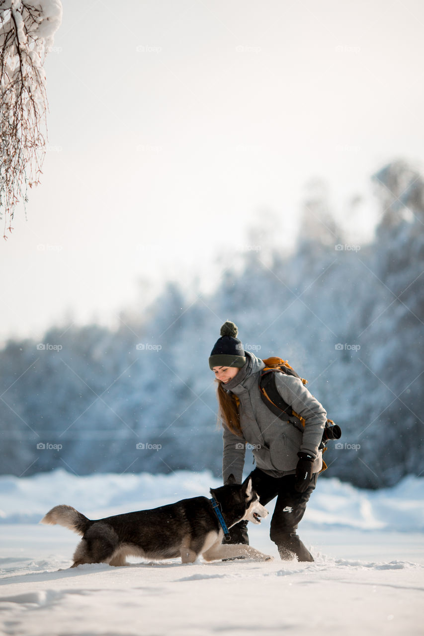 Walking with husky in winter park at sunny cold day