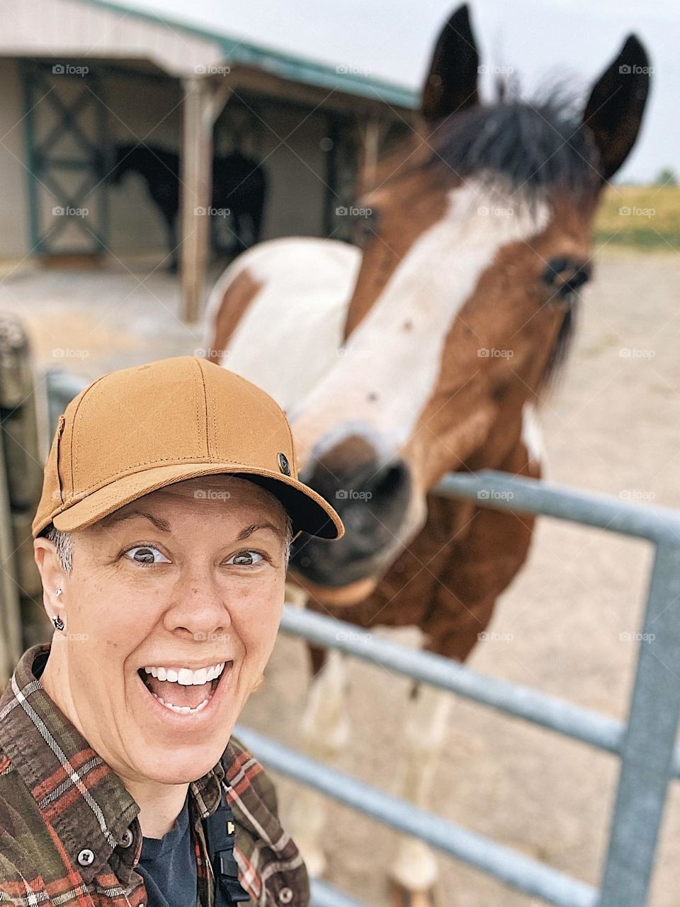 Woman takes selfie with horse, horse tries to grab woman’s hat during selfie, taking a selfie with a horse, animals and selfies, taking a selfie on the farm 