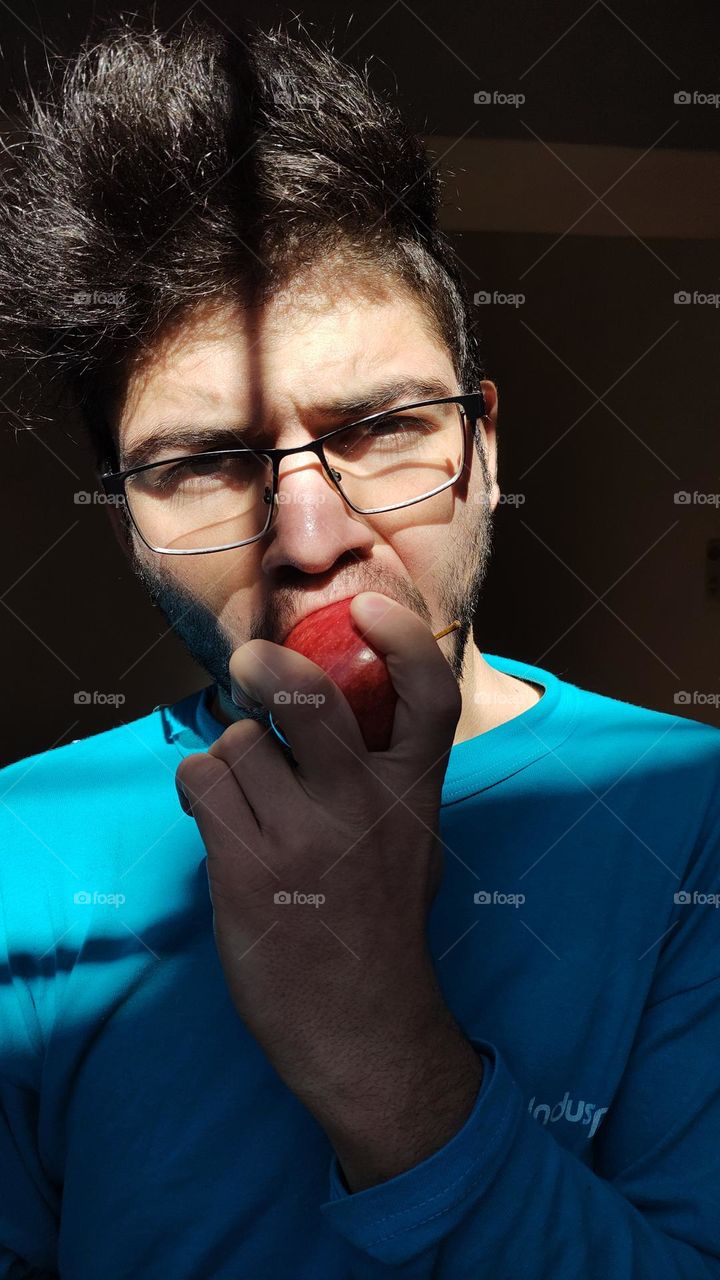 foto hombre comiendo manzana con remera celeste