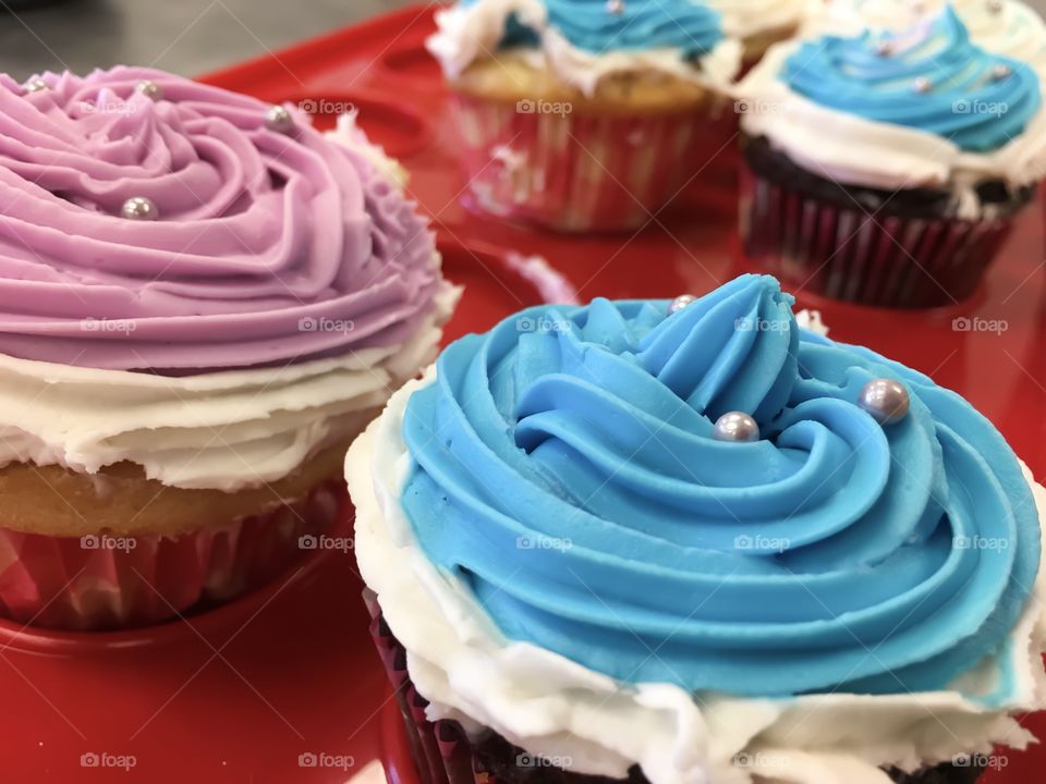 Crazy cupcake in fun blue and pink swirl vanilla frosting and sprinkles for office party celebration 