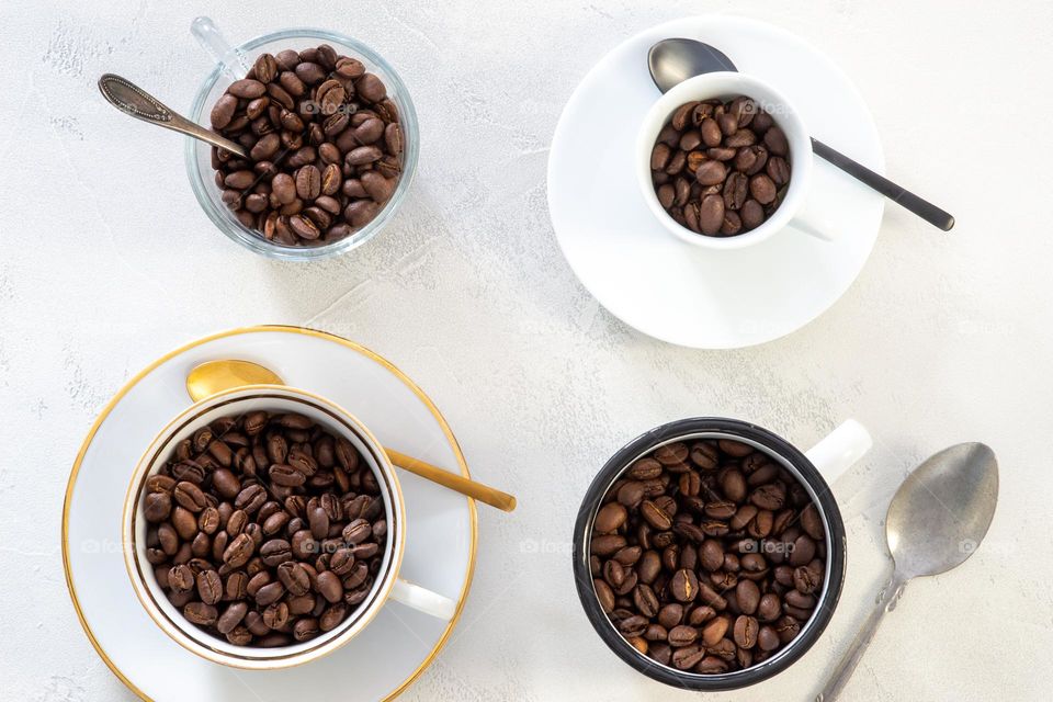 four different coffee cups filled with coffee beans