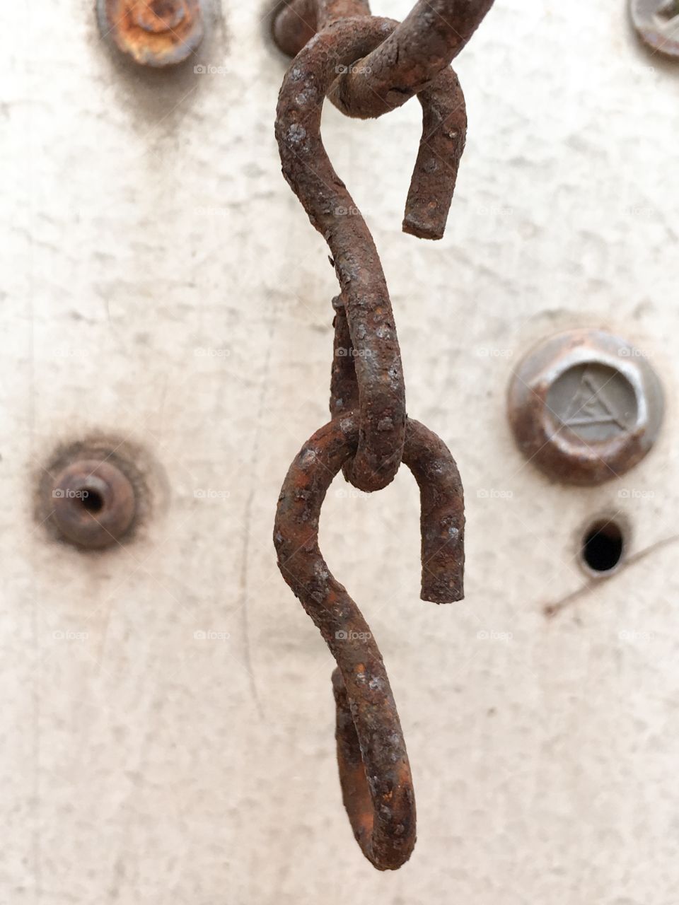 A macro image of a rusted s hook hanging from an old structure, grunge 