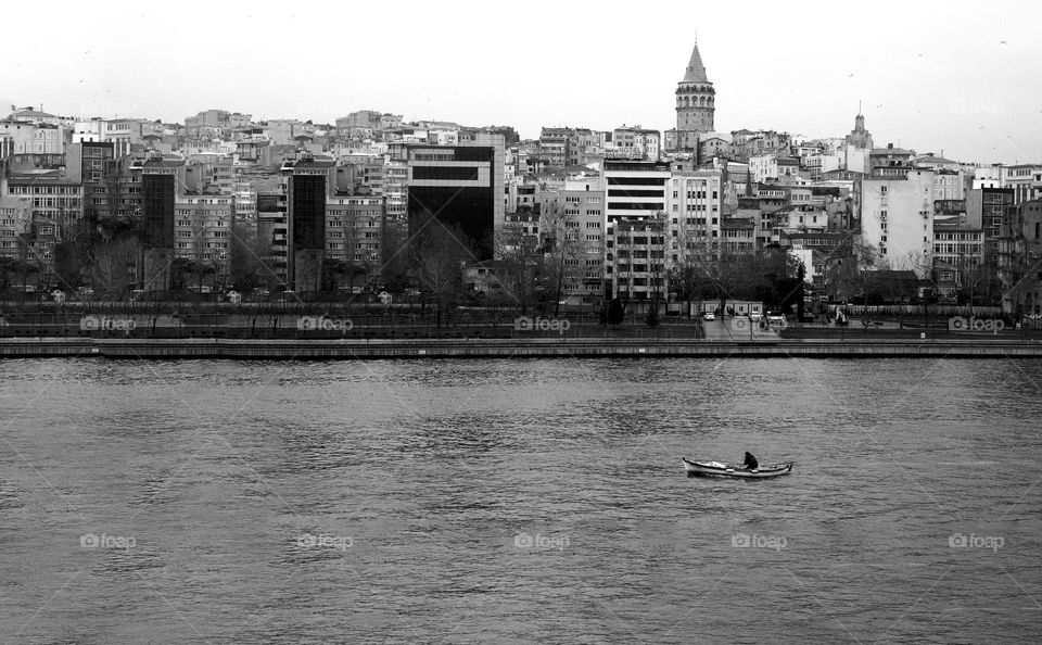 Man traveling in a boat next to a city