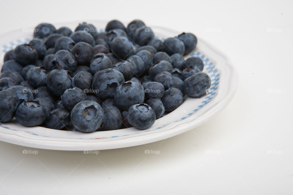 Fresh blueberries in white bowl side view