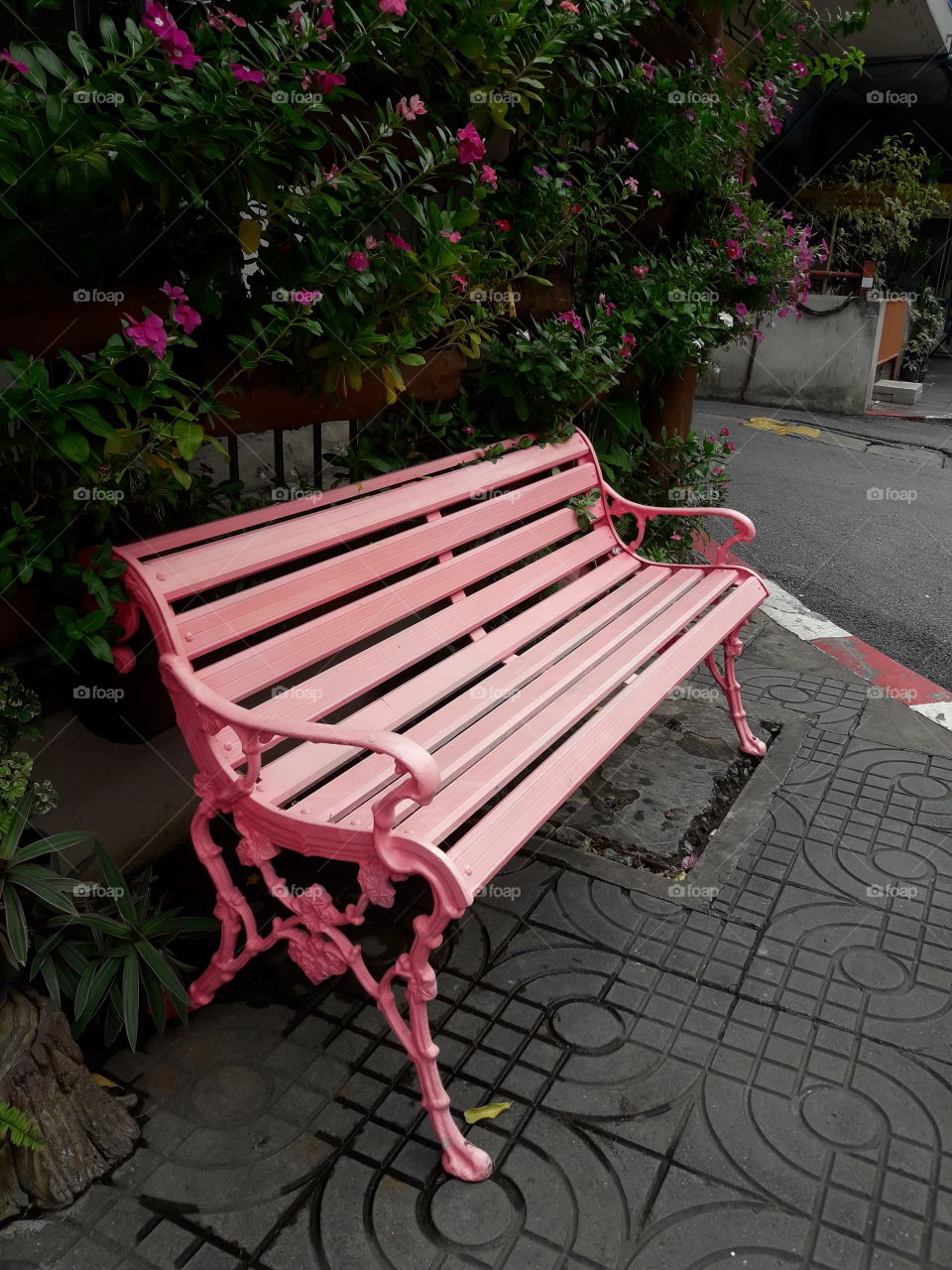 another view of pink longchair placed on footpath.