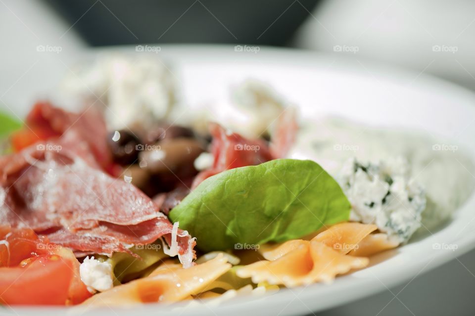 close-up of a young man eating a salad in a light kitchen